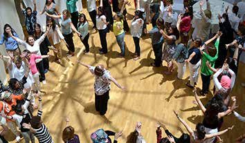 A large group of women standing in a circle during a Women In Abu Dhabi (WIAD) wellbeing session.