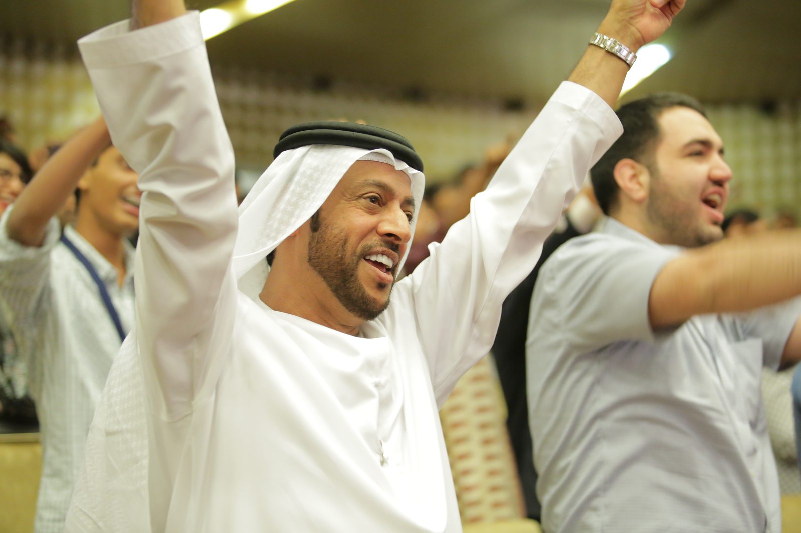 An audience member throws his arms up celebrating during a Jo-Dee Walmsley session built on The L.A.U.G.H.T.E.R. Method®.