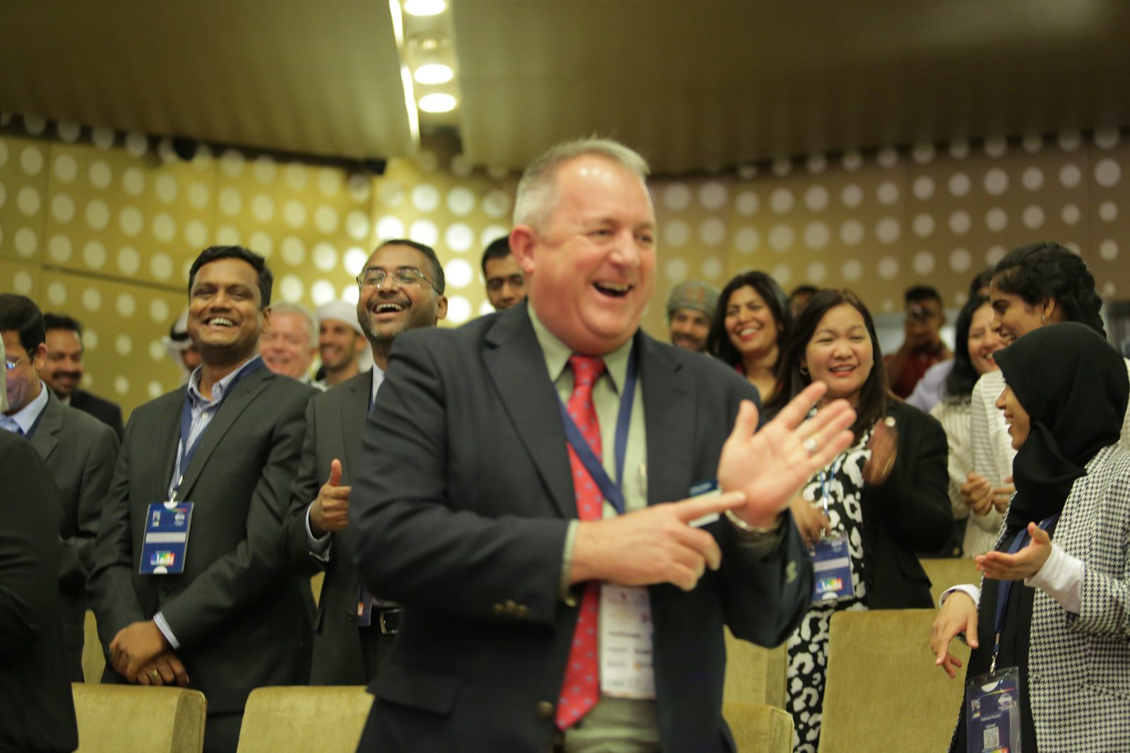A corporate audience applauding and laughing together during a Jo-Dee Walmsley keynote.