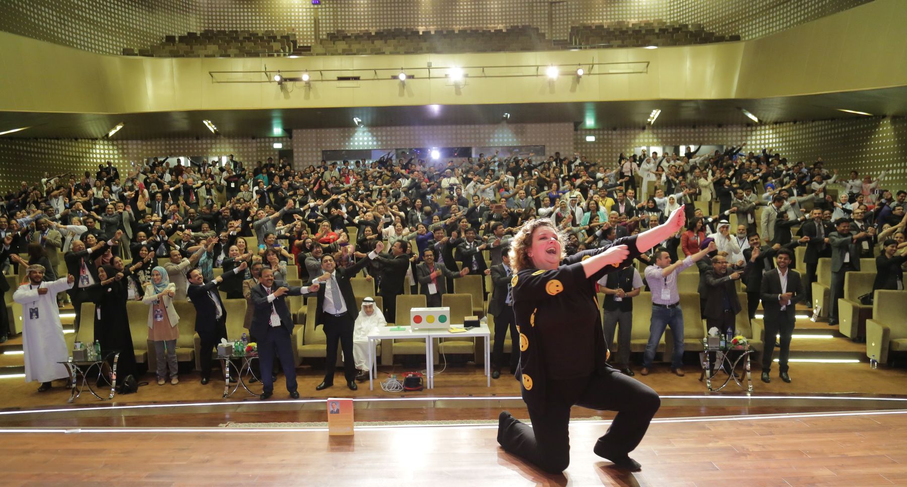 Jo-Dee Walmsley leading a full auditorium of hundreds of delegates through an interactive exercise on stage at an international conference.