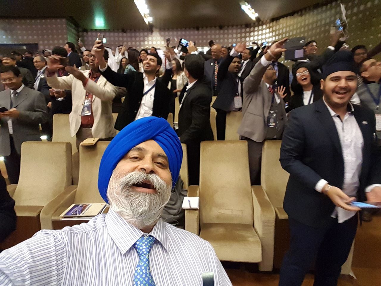 Jo-Dee Walmsley leads an international conference audience through the Selfie Laughter® exercise, with hundreds of delegates on their feet, phones raised, laughing together.